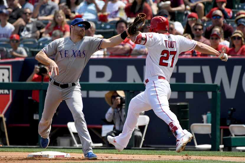 Texas Rangers first baseman Logan Forsythe, left, tags out Los Angeles Angels' Mike Trout...