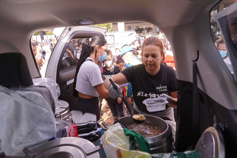 Voluntarios sirven comida caliente desde el interior de un vehículo tras las inundaciones en...