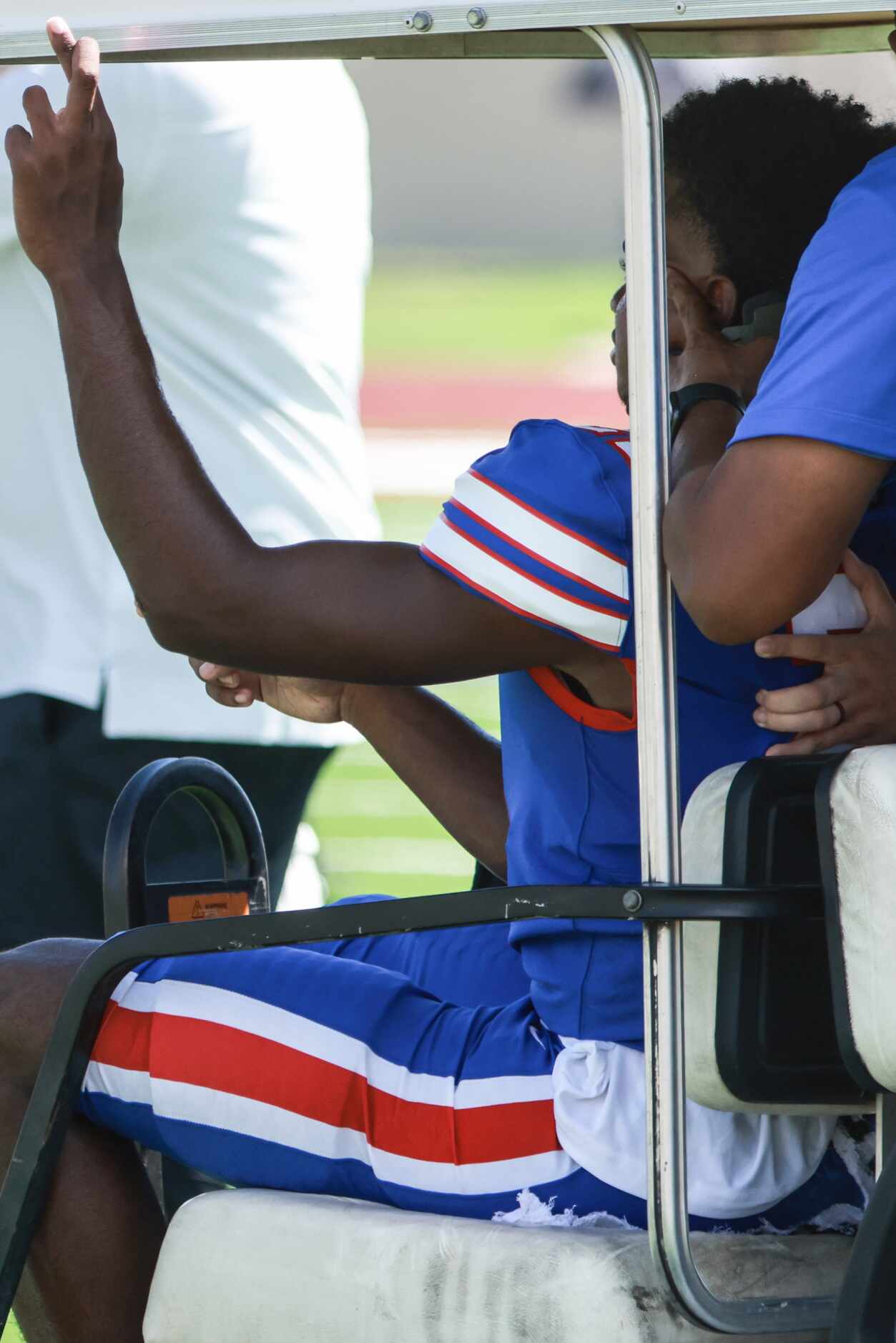 Duncanville High School Tyren Polley (21) crosses his fingers as he’s hauled off the field...