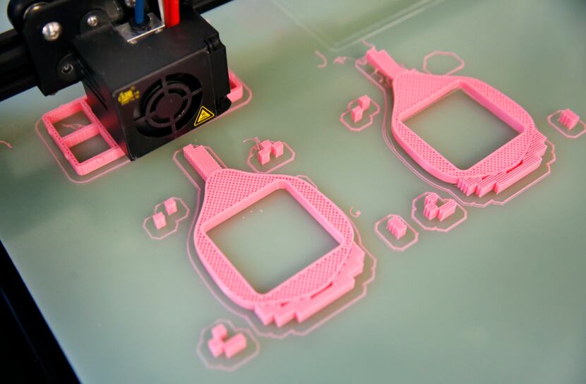 A 3-D printer creates a pink respiratory mask at Unique Software Development on N. Central...