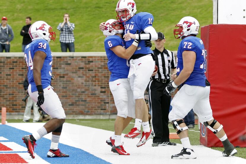 SMU quarterback Garrett Gilbert (11) celebrates his touchdown run with running back Traylon...