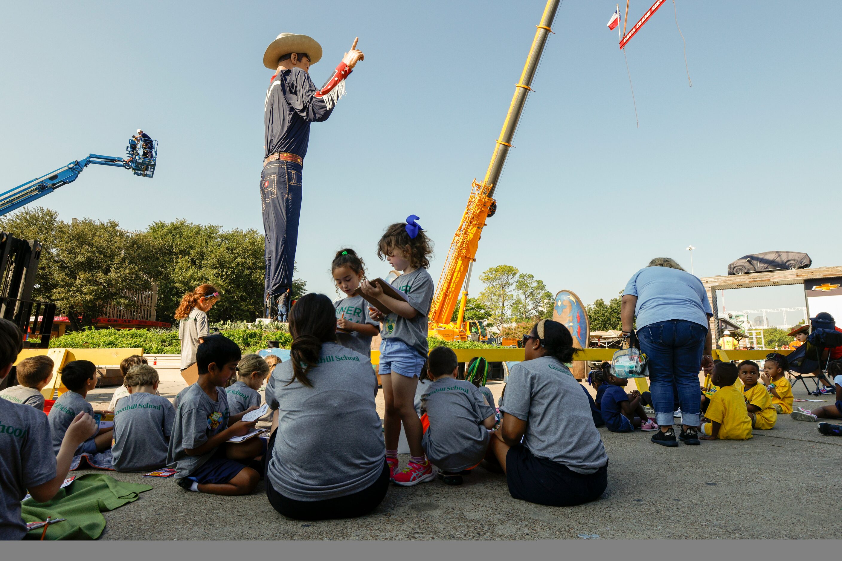 Children from the Greenhill School watch as crews lift Big Tex at The State Fair of Texas,...