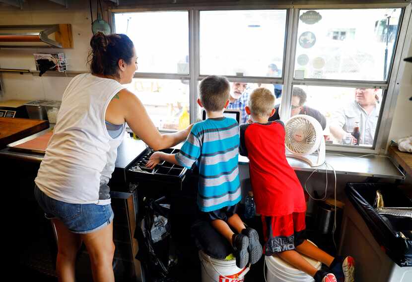 Brandi Alejandro (left) helps Elliot Guess (center) and Ryan Hayes take orders at the...