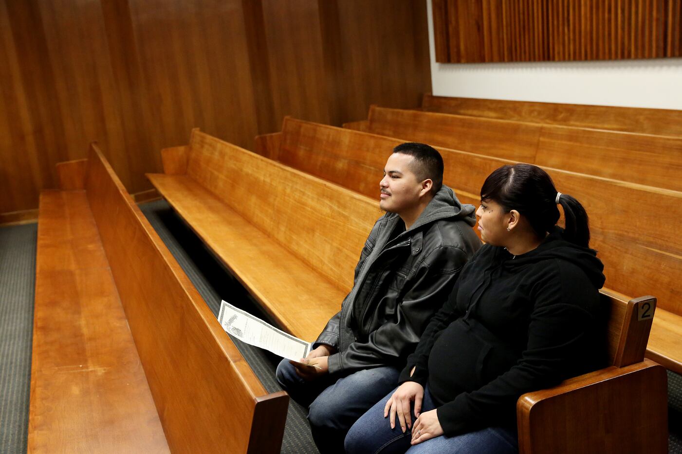 Gonzalo Ramirez and Lizette Torres, both of Dallas, wait to get married in the court room of...