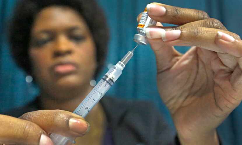 Dawnn Walker prepares to administer an immunization at the Dallas Mayor's Back to School...