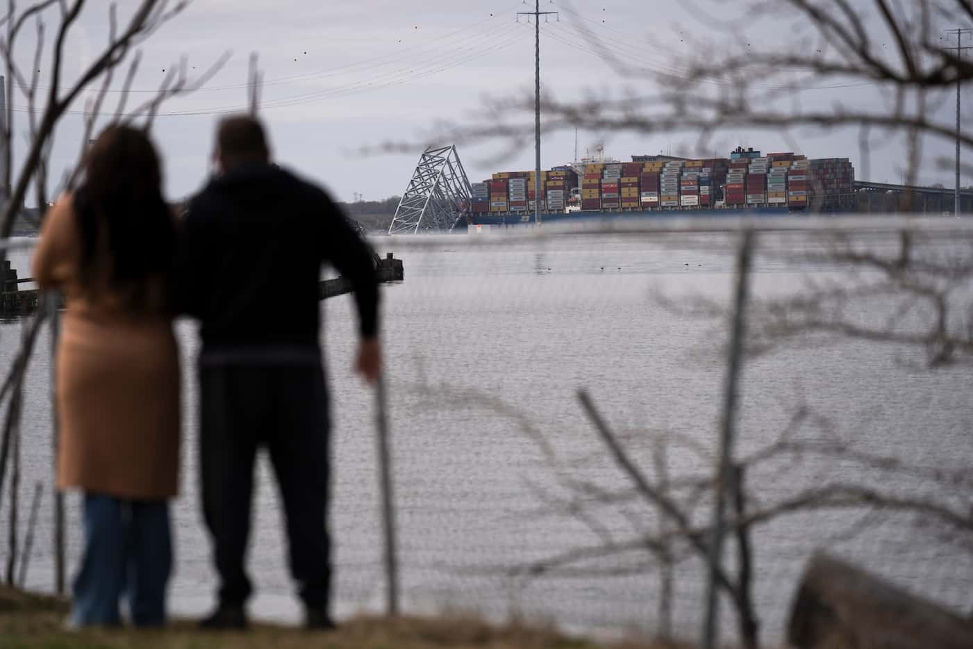 People view the container ship as it rests against wreckage of the Francis Scott Key Bridge...