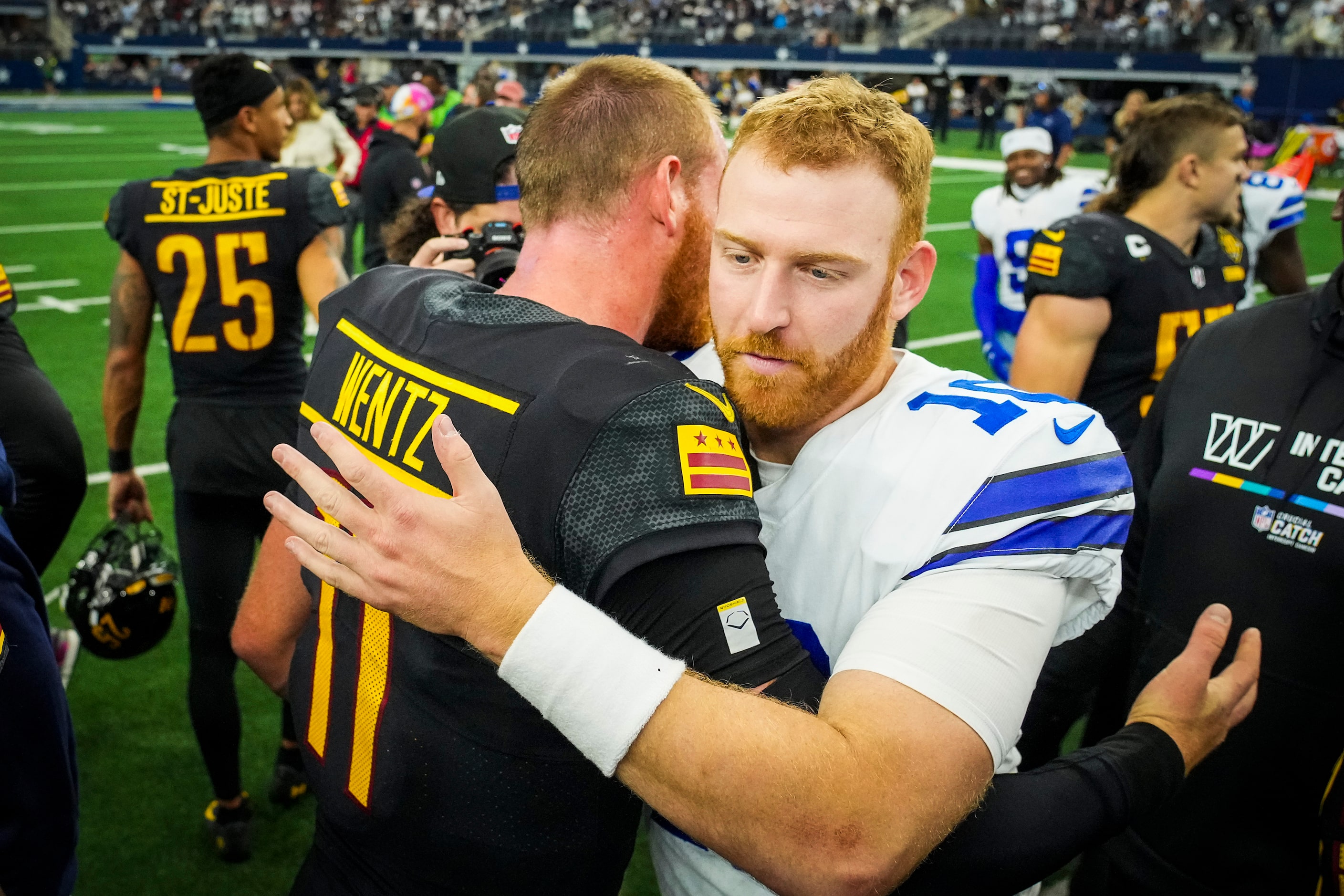 Dallas Cowboys quarterback Cooper Rush (10) hugs Washington Commanders quarterback Carson...