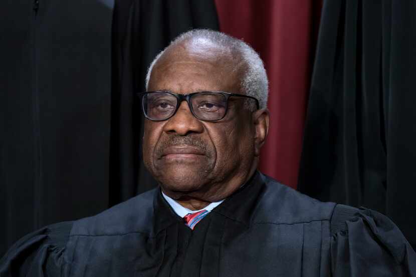 Associate Justice Clarence Thomas joins other members of the Supreme Court as they pose for...