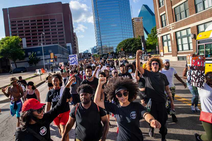 Tierra Jenae Giles (center) leads protesters as they march in a demonstration denouncing...