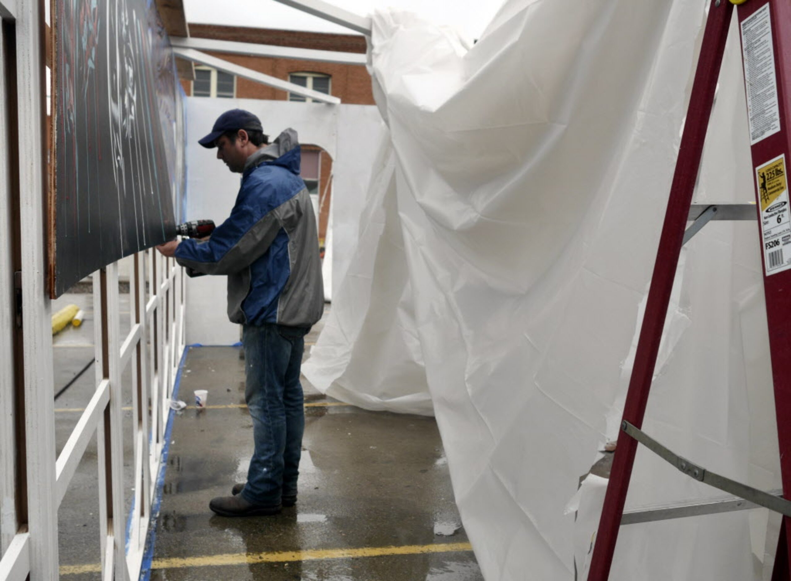 Jeff Kiec removes the last mural from the "tunnel" on Sunday at the Deep Ellum Arts Festival.