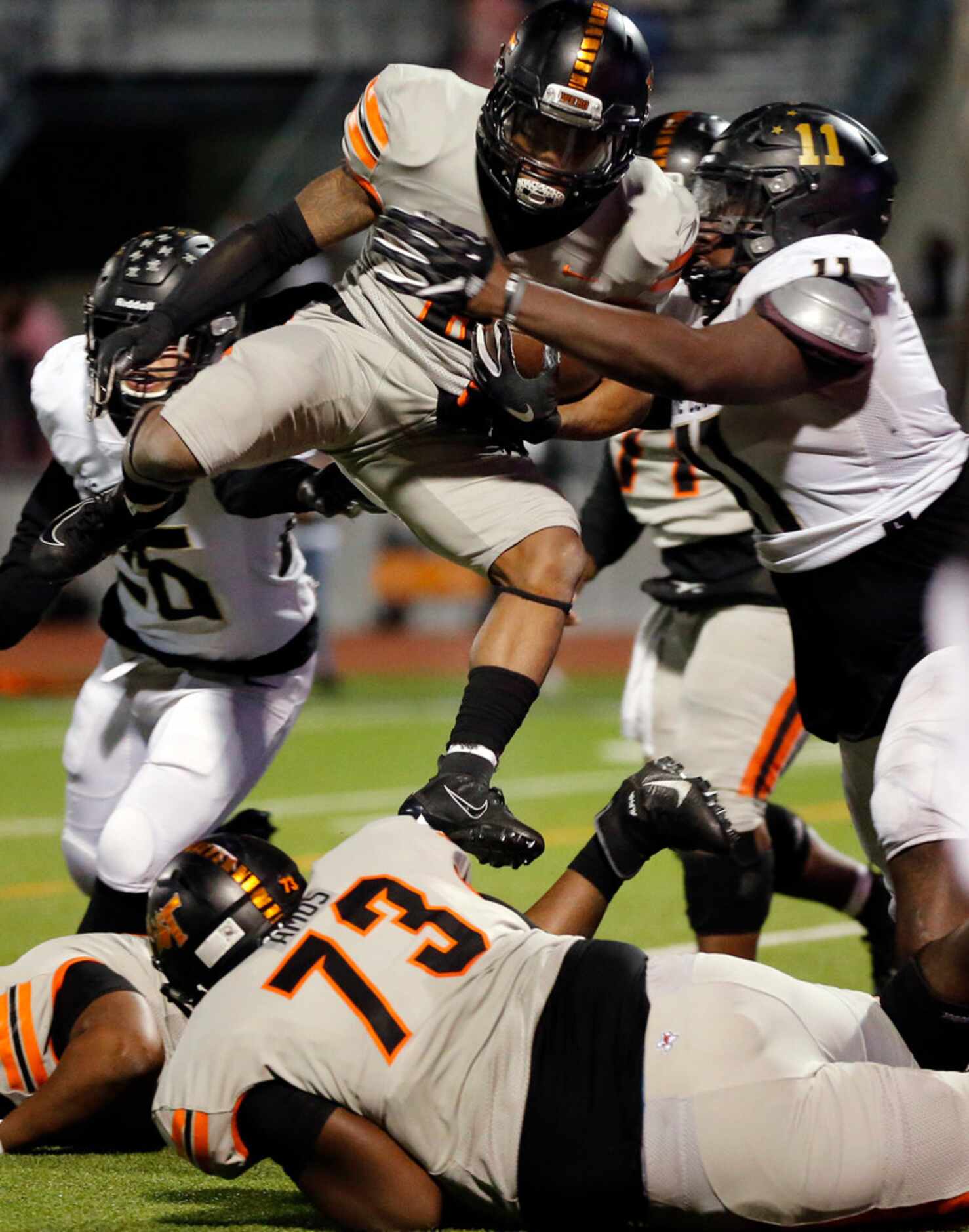 Lancaster running back DQ James (6) hurdles his teammate as he's hit by The Colony's Marcus...