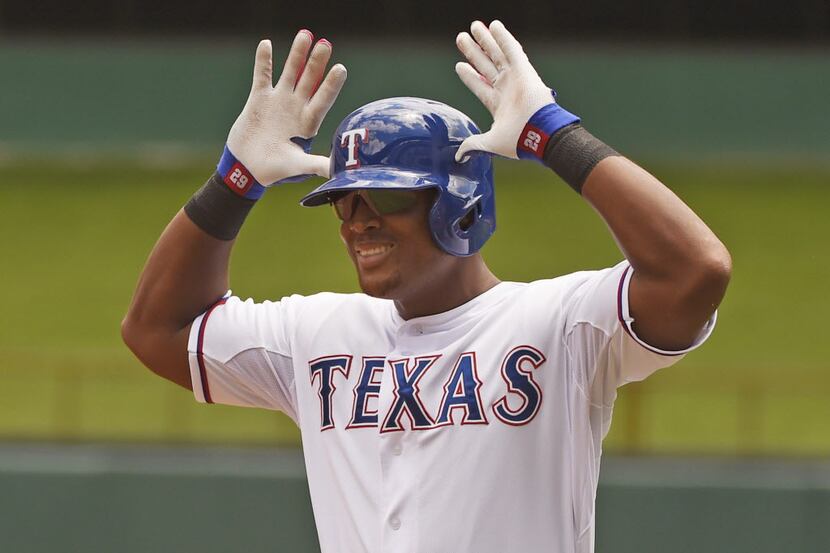 Texas Rangers third baseman Adrian Beltre (29) flashes the antlers sign after he beat out a...