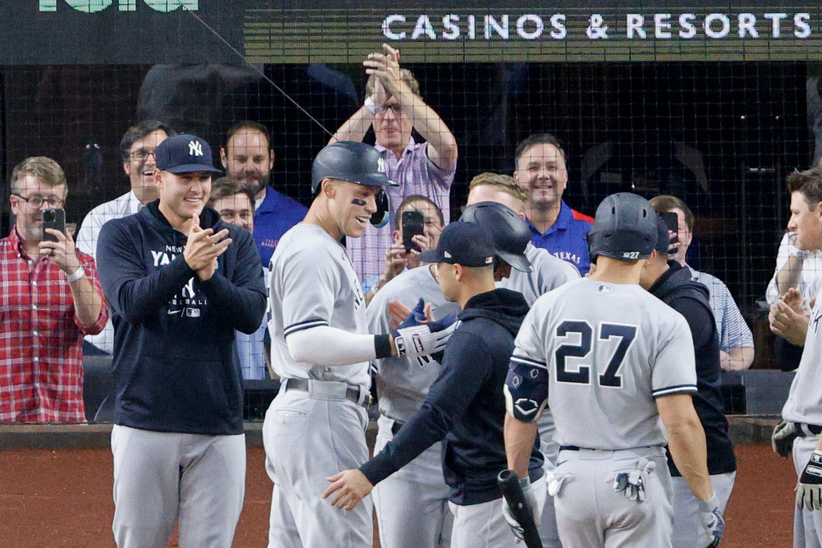 Members of the New York Yankees greet New York right fielder Aaron Judge (99) after he hit...