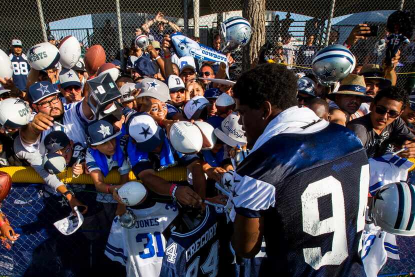 Dallas Cowboys fans reach for an autograph from defensive end Randy Gregory (94) after the...