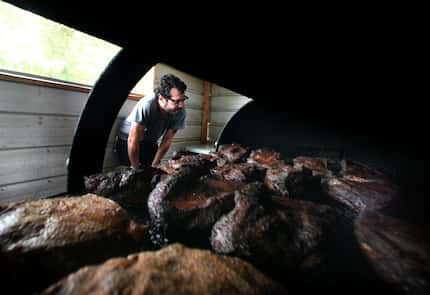 Aaron Franklin of Franklin Barbecue peeks inside his pit. He does this a lot, but he's a...