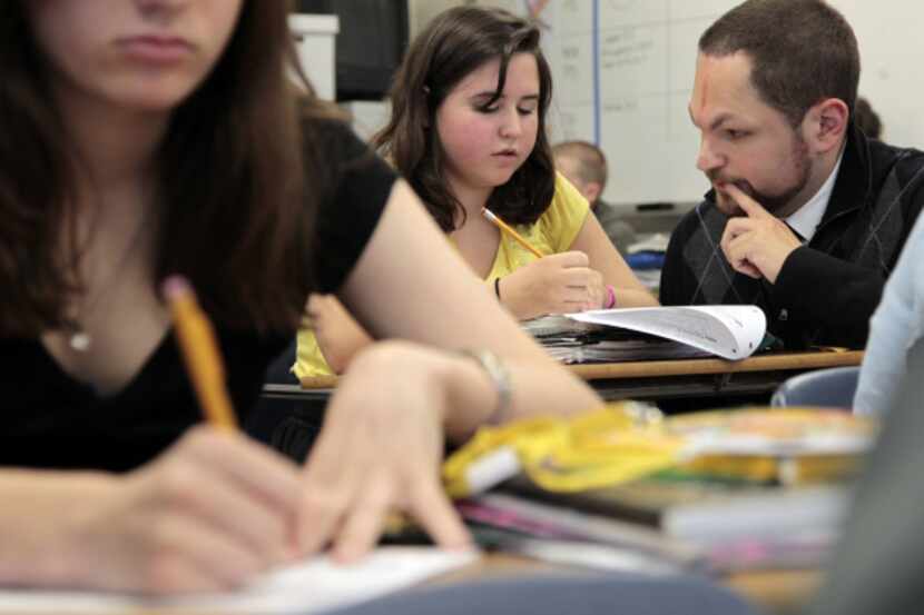 Substitute teacher John Zancana helps Katharine Jovicich, 14, with a math problem in during...