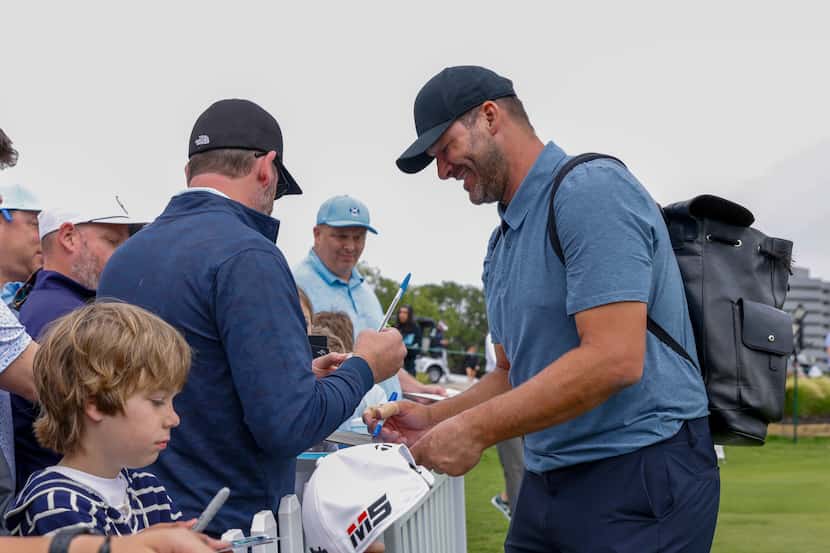 Former Dallas Cowboys quarterback Tony Romo signs autographs for fans after the first round...
