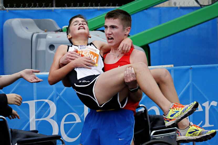 Trace Greer (right) carries his brother Judson Greer after they crossed the finish line...