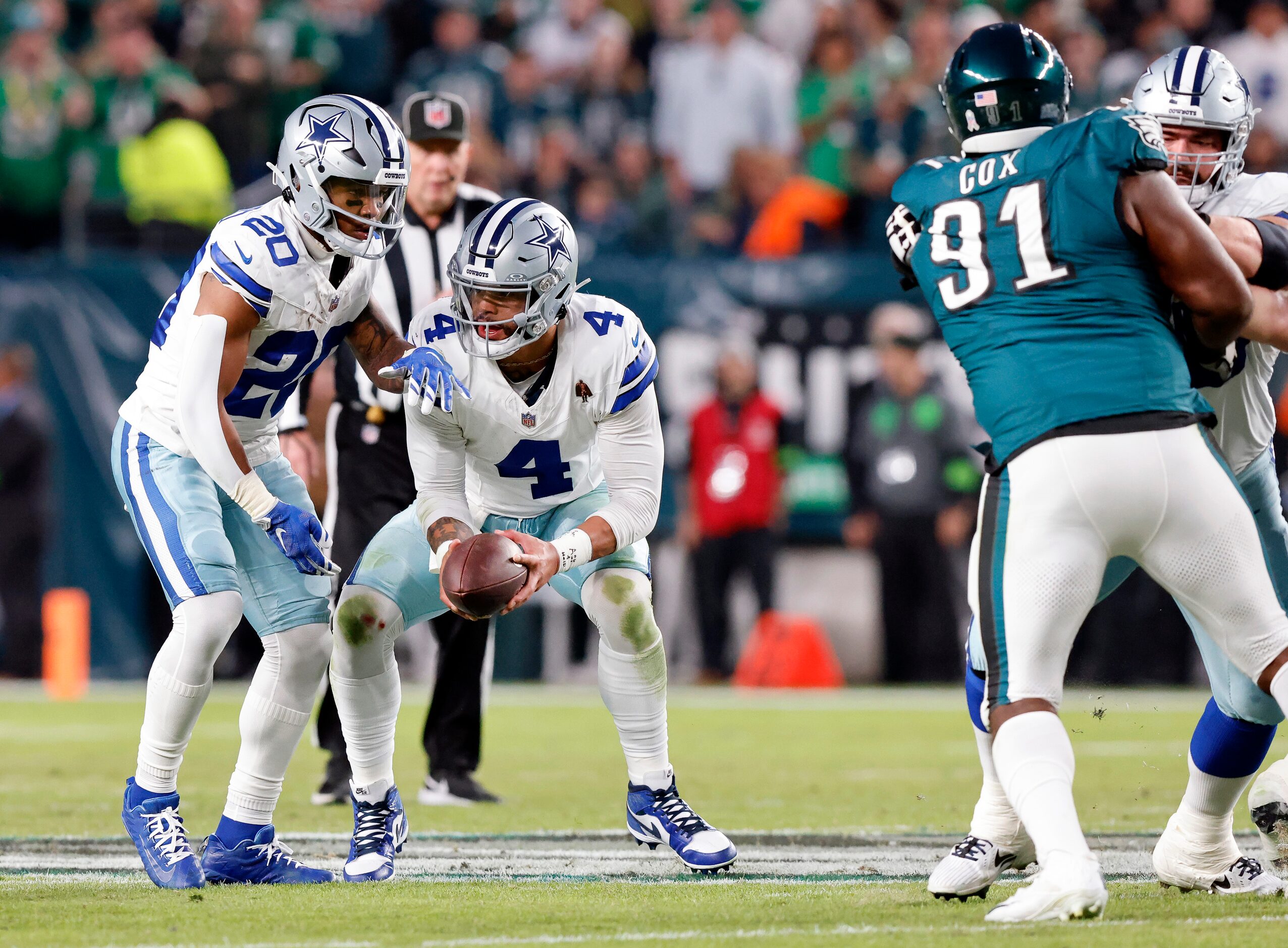 Dallas Cowboys quarterback Dak Prescott (4) hands the ball to running back Tony Pollard (20)...