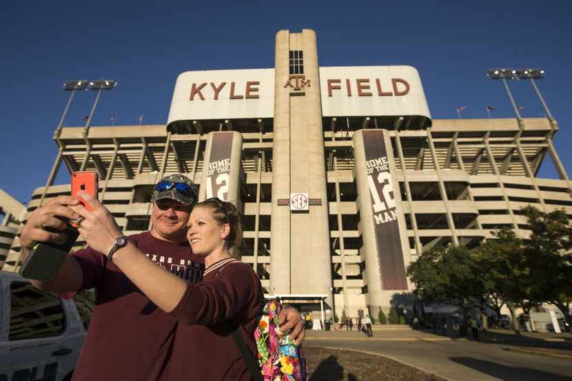Texas A&M fans Clint and Nicole Ellis, of LaVernia, take a photo of themselves outside the...