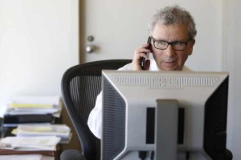  Dallas City Manager A.C. Gonzalez takes phone calls in his office following the...