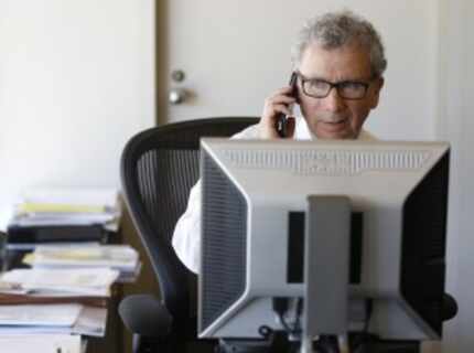  Dallas City Manager A.C. Gonzalez takes phone calls in his office following the...