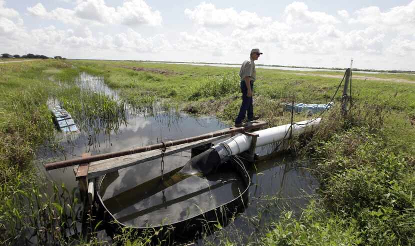 In this Sept. 20, 2011 file photo, rancher and farmer Victor Corporon looks over a pump...