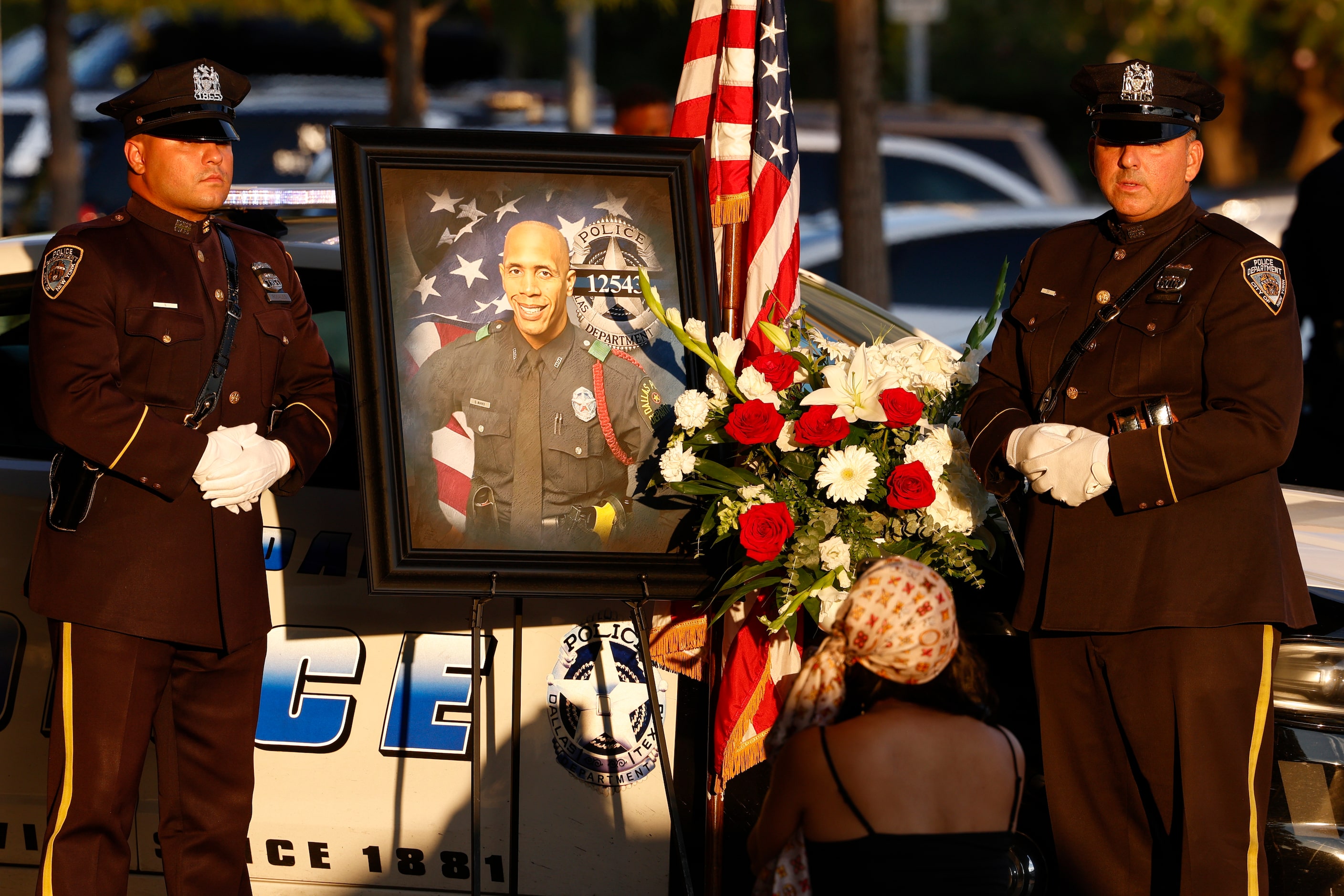 New York City police officers pose for a photo during a public visitation for Dallas police...