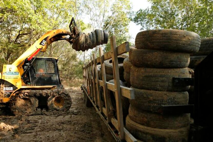 
Rene Castro loads tires from the Trinity River onto a truck for removal. Good Earth Inc....