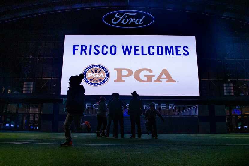 Visitors play on the field as a message welcoming the PGA of America to Frisco, Texas is...