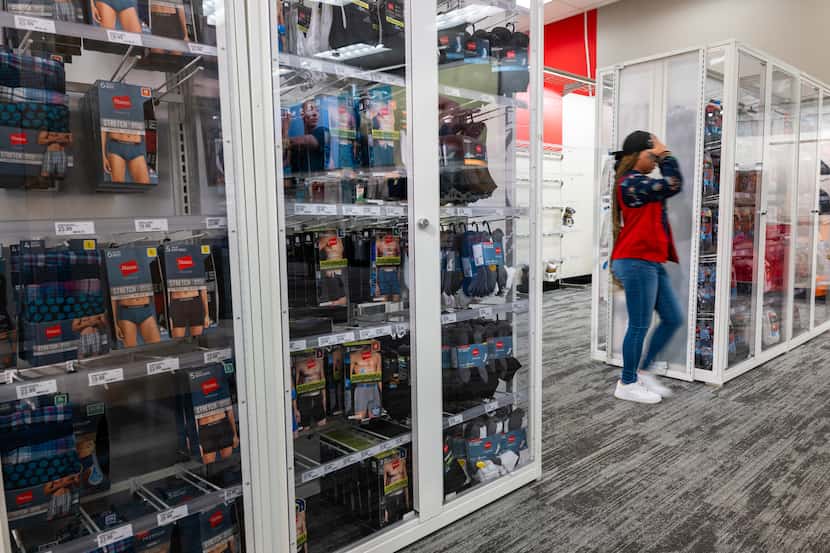 Products sit behind plexiglass at a Target store in New York City. Walmart has installed...