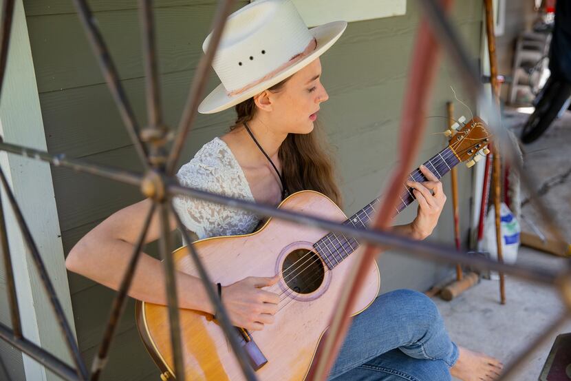 Musician and yoga instructor Jenna Clark plays guitar in the backyard of her Oak Cliff home....