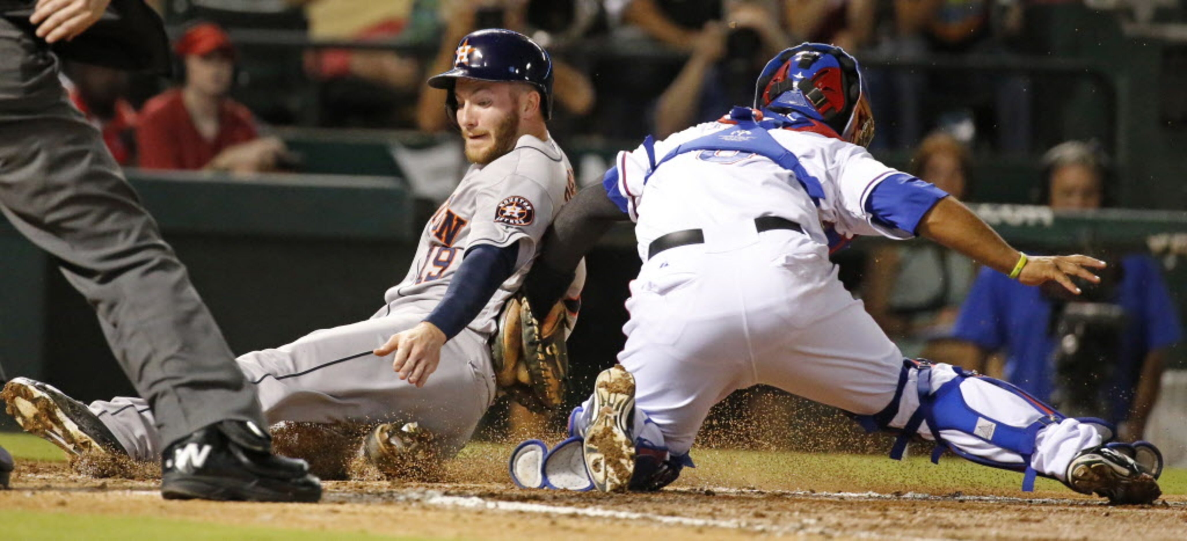 Houston's Robbie Grossman is tagged out at home by Texas catcher Tomas Telis as he tries to...