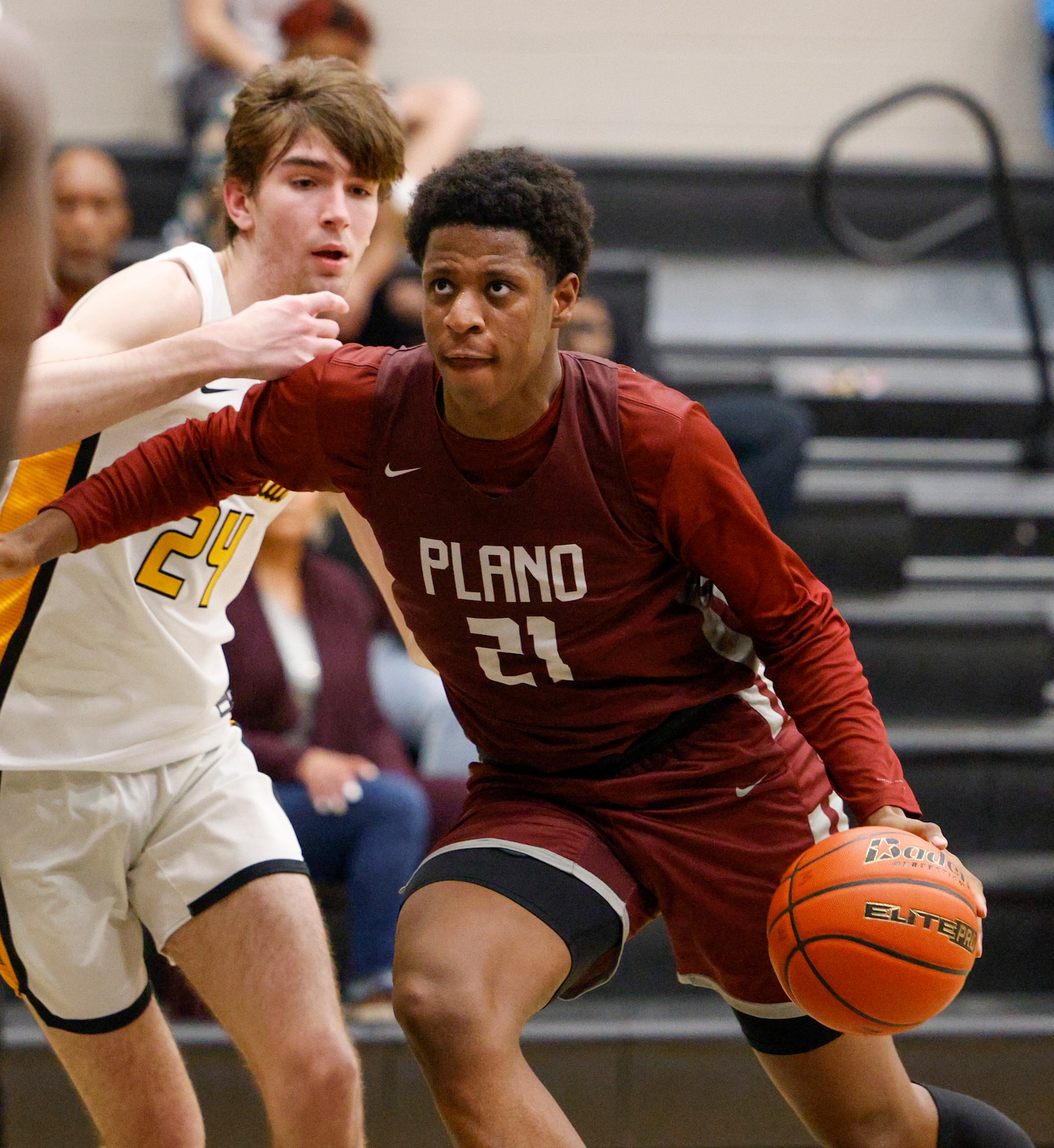 Plano forward Justin McBride (21) dribbles past Frisco Memorial forward Cooper Mendel (24)...