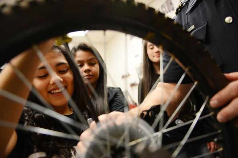 
Eighth-grader Lezly Padilla repairs the gears on a bicycle during Garland ISD's...