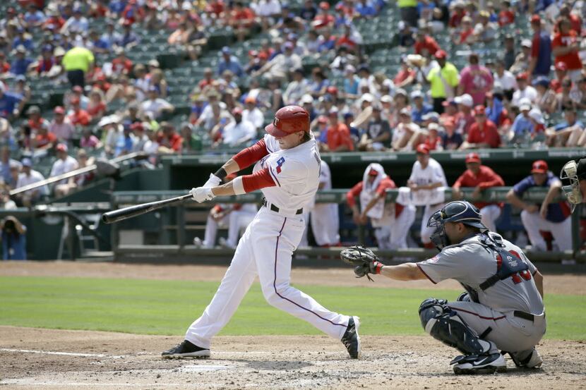 Texas Rangers' Jim Adduci follows through on a single to left off a pitch from Minnesota...