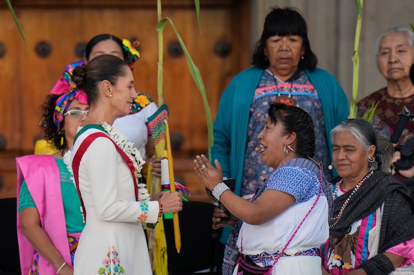 La presidenta de México Claudia Sheinbaum durante la ceremonia con una mujer indígena, en el...