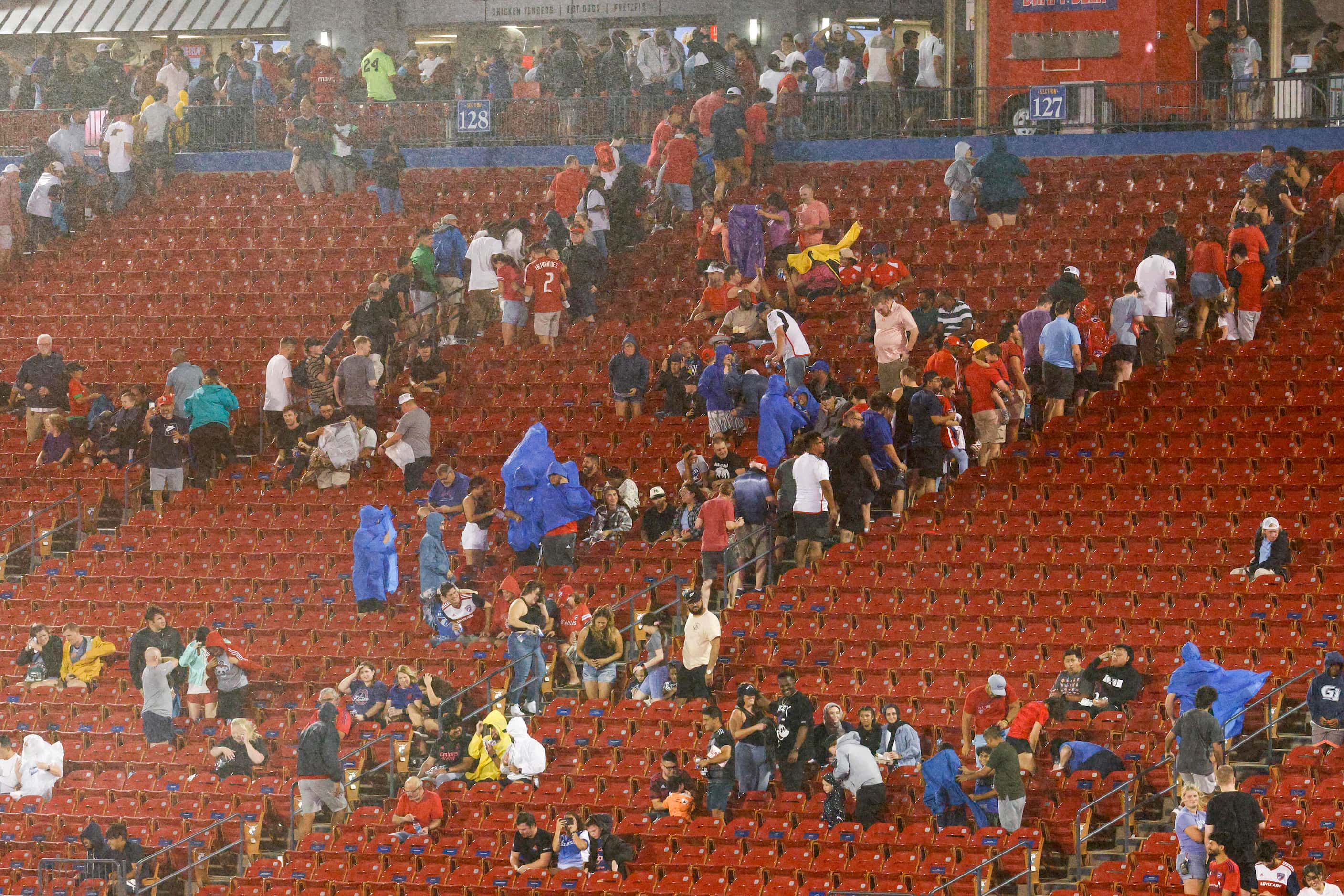 Soccer fans head for shelter as rain begins to fall during a lightning delay before an MLS...