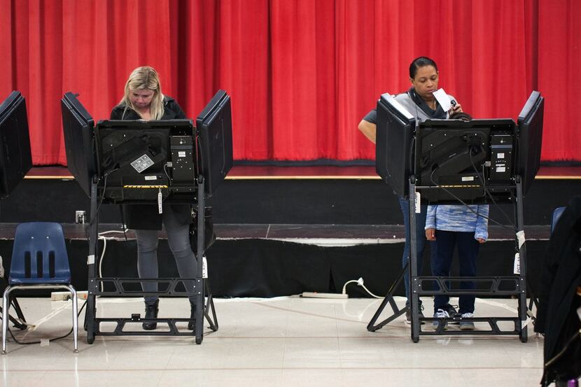 Tammy Moore, a resident of Mecklenburg County,  casts her vote with the assistance of her 7...