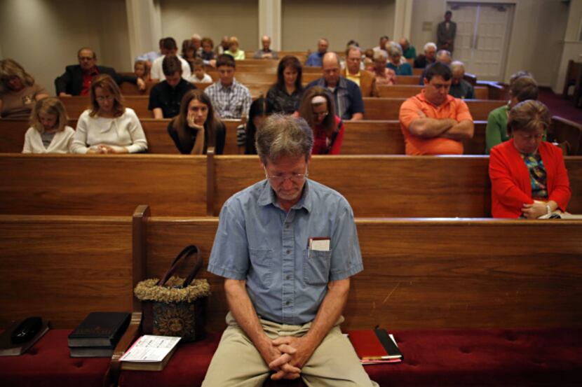Dan Lautz and other churchgoers at First United Methodist in Forney bowed their heads Sunday...