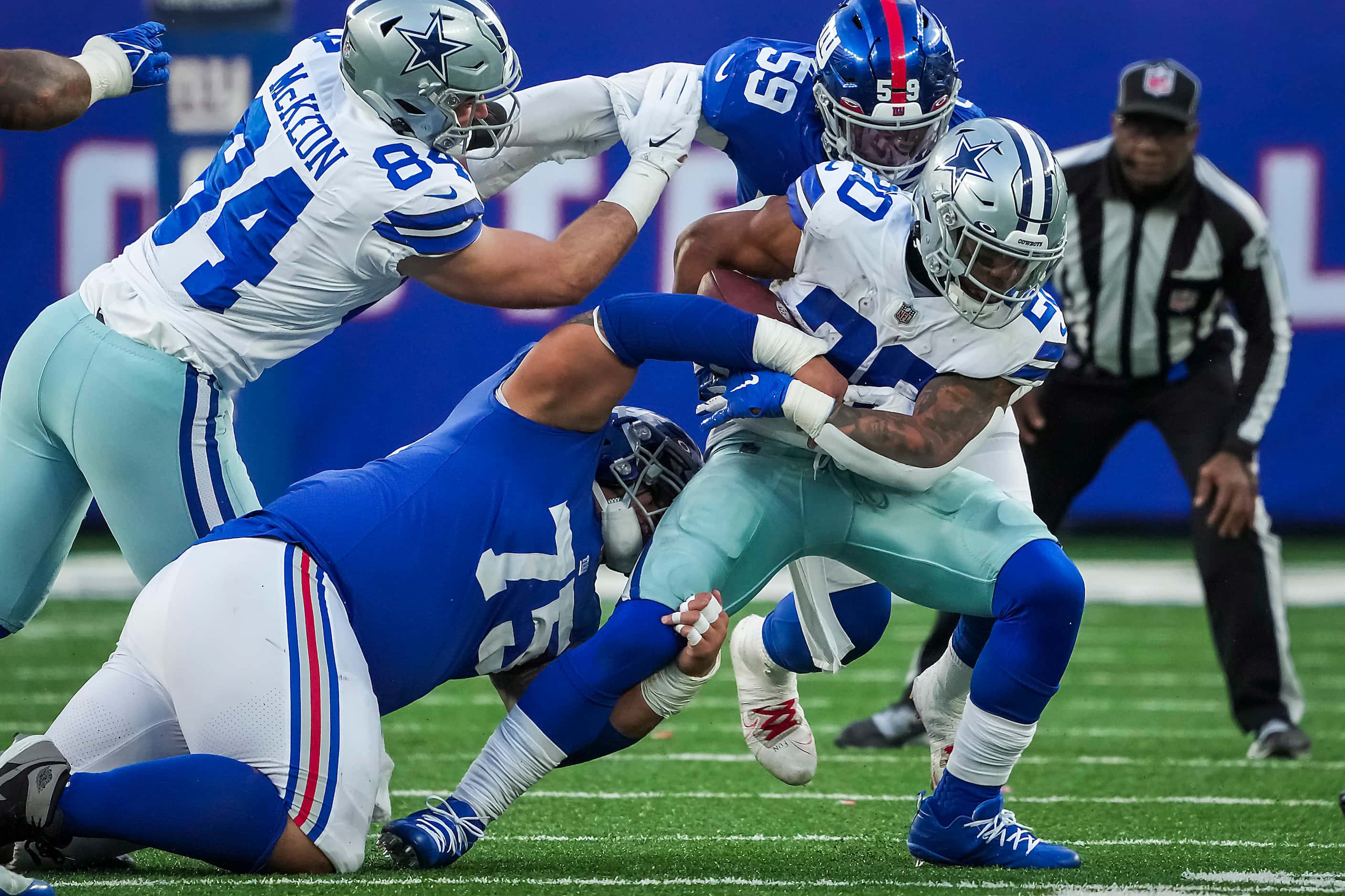 Dallas Cowboys running back Tony Pollard (20) is brought down by New York Giants defensive...