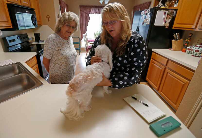 Tammy Miller (right), manager of Tri-City Animal Shelter, checks Jackie Merrell's 8-year-old...