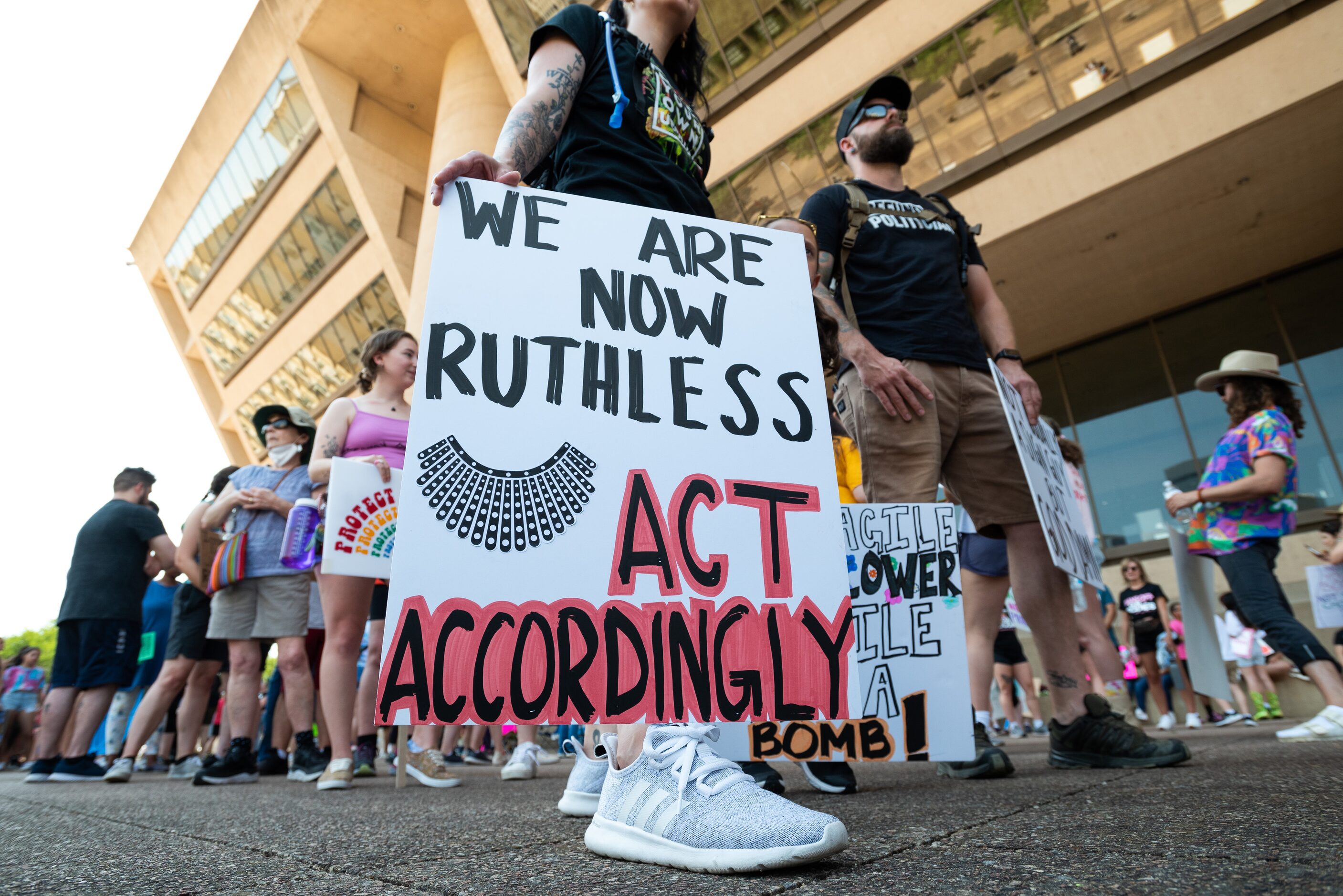 Erica Hellrung, 35, with sign, and her boyfriend T.J. Anderson, 39, right, both of Prosper,...