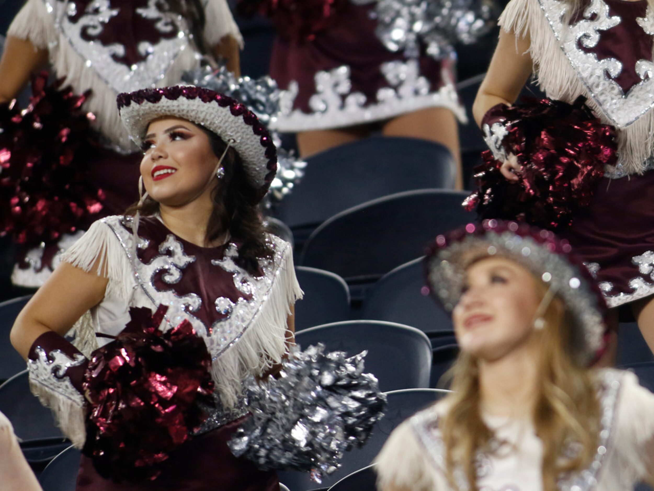 A Red Oak Hawks drill team member looks upward to the replay screen following a long gain by...