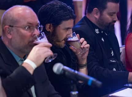 Eric Tecosky, national brand ambassador for Jack Daniels, center,  tastes Keisha Cooper's...