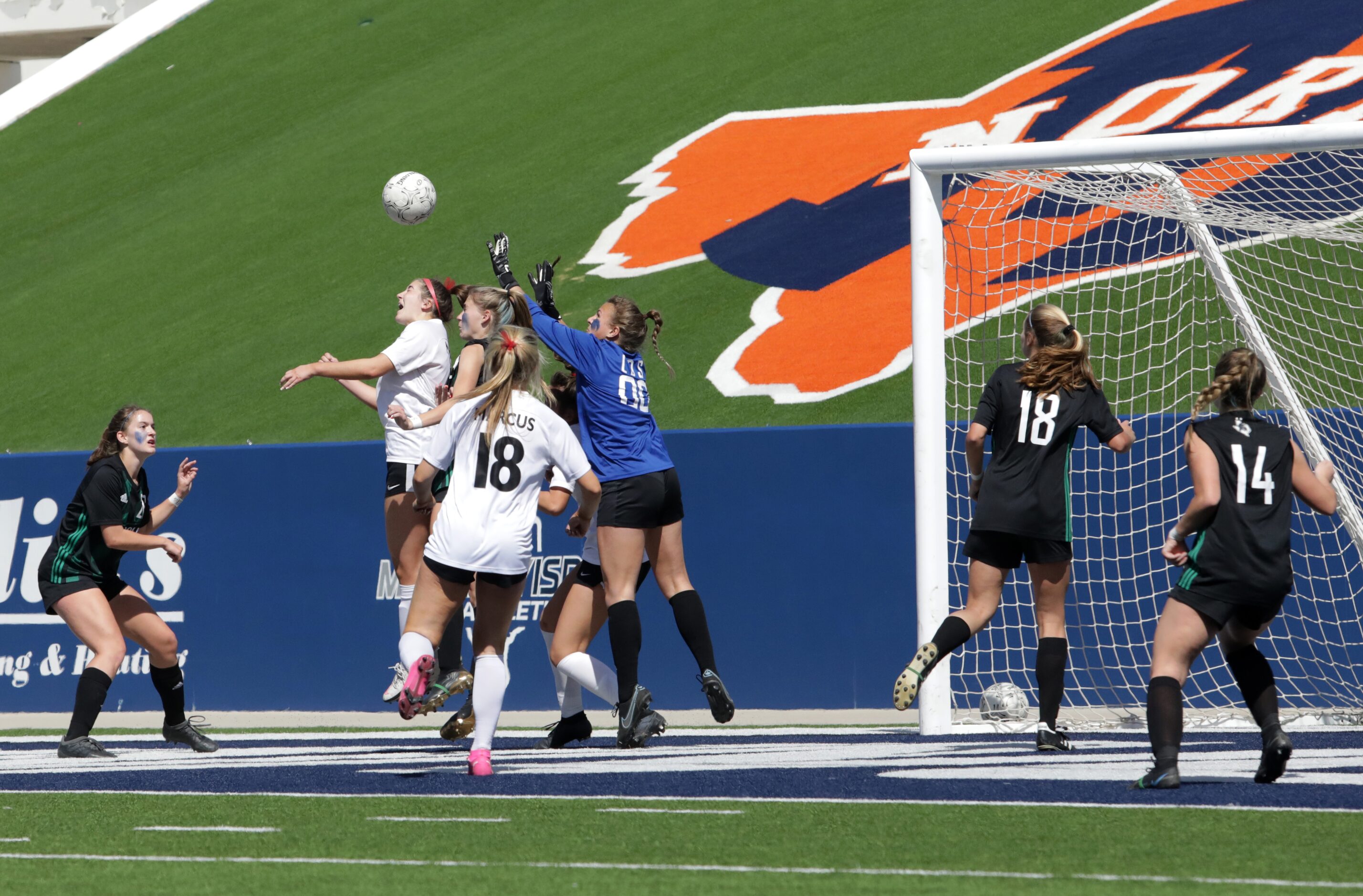 Southlake Carroll players and Flower Mound Marcus players fight for the ball during a Class...