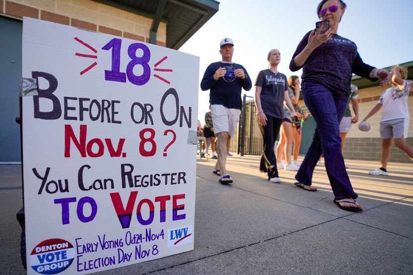 Fans arriving for a high school football game between Denton Guyer and Prosper pass a voter...