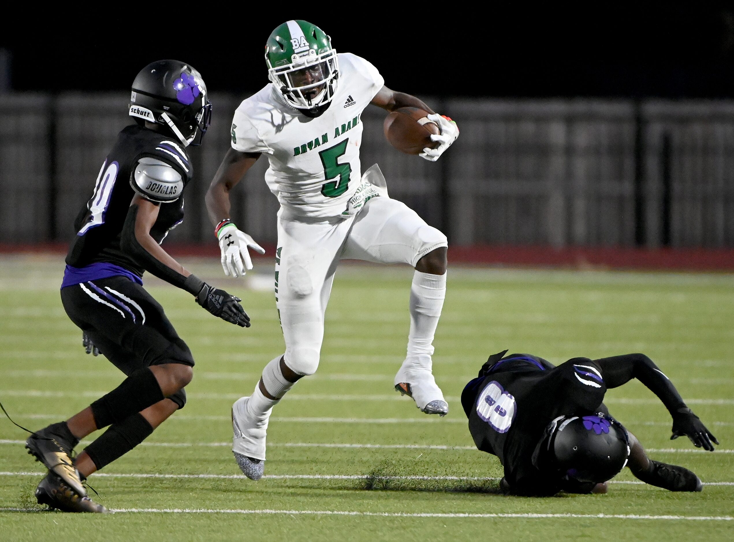 Bryan Adam’s  Antoine Murphy (5) runs between Lincoln’s Jeremiah Harper (29) and Donnell...