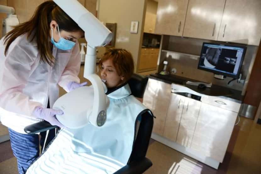 
Dental assistant Marta Lira takes a mouth X-ray of Ariadna Chaparro, 10, at the Grand...