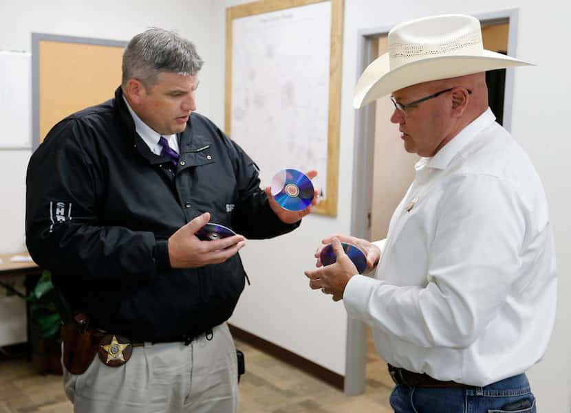 Wise County sheriff investigator Luke Campbell hands over DVD copies of evidence to special...